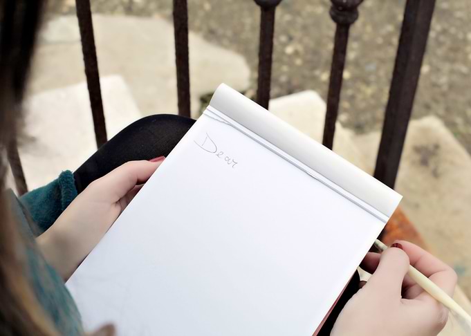 Romantic girl writing on n