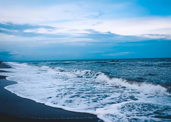 Ocean waves kissing the be