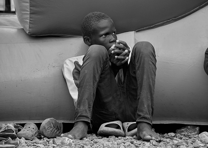 Young Boy Sitting by Inflatable Structure