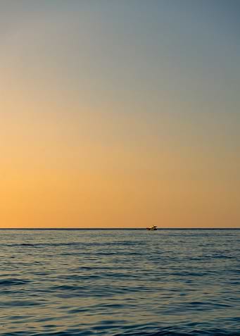 Boat on Calm Sea at Sunset