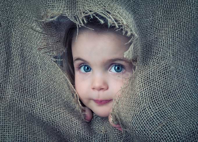 Little Girl Peeking Through Burlap