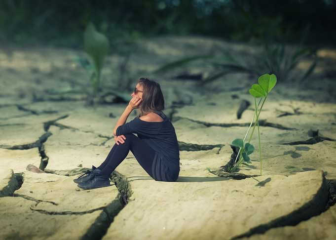 Woman Sitting on Cracked Earth