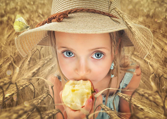 Girl Eating Apple in Wheat Field
