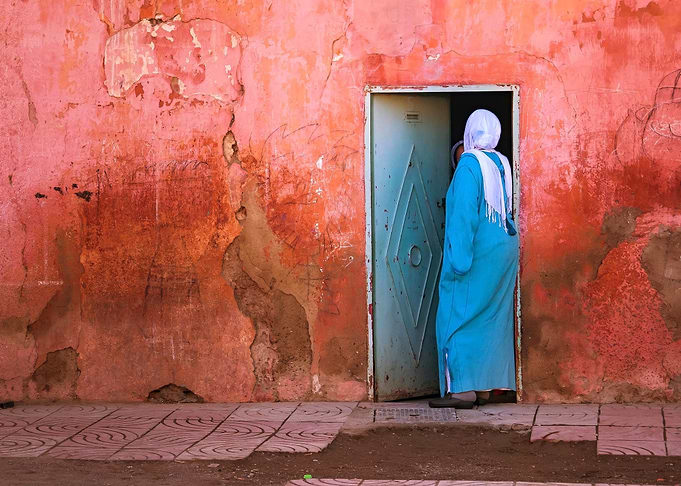 A Muslim woman in front of a house in Morocco