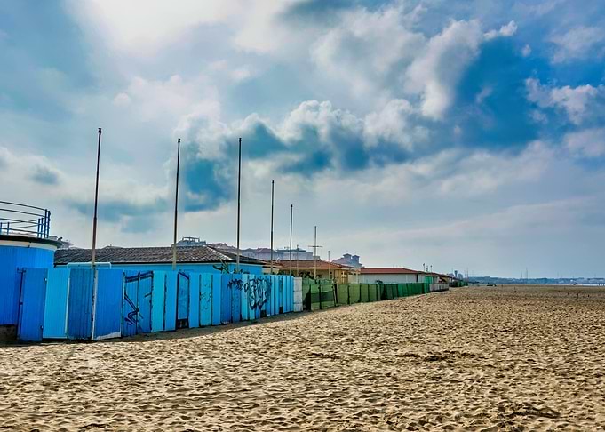 Versilia Beach Cabanas Under Cloudy Sky