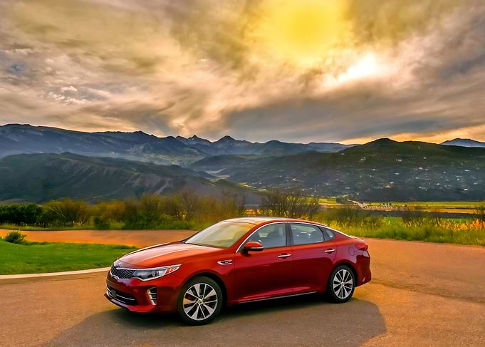 Red Kia Optima in Mountain Landscape