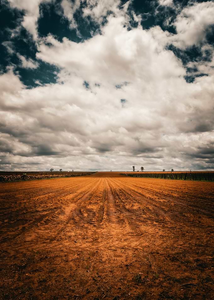 Plowed Field Under Cloudy Sky