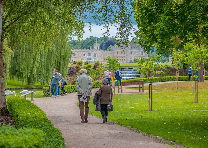 Couple Walking in Park,Leeds Castle in background.