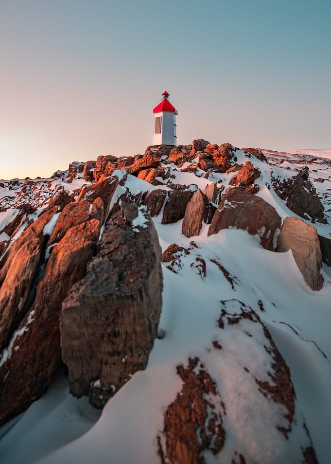 Lighthouse on Snowy Cliff