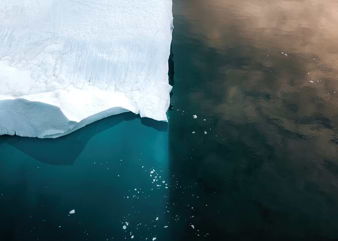 Aerial photo of an Iceberg floating in the arctic ocean in Greenland at sunset