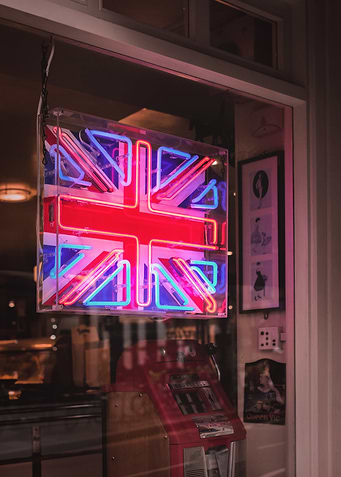 London, England I Neon light of the United Kingdom flag in a moody dark window on a Londoner street to the vibrant cosmopolitan spirit of the English capital with abstract analog film photography