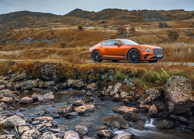 Orange Bentley on a Mountain Road