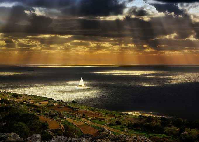 Sun rays on sea at sunset with cliffs - Landscape photo