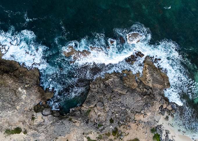 Aerial View of Ocean Waves Crashing on Rocks