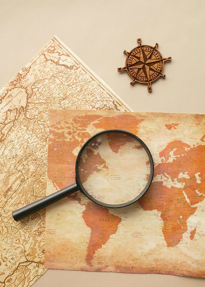World Map with Compass and Magnifying Glass