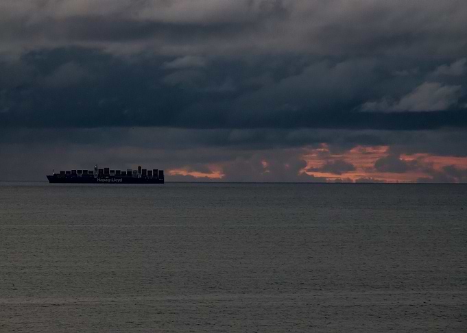 Cargo Ship at Sea with orange sky