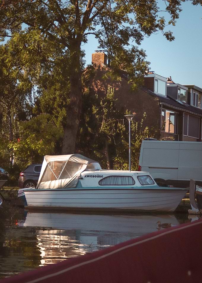White Boat Docked by House