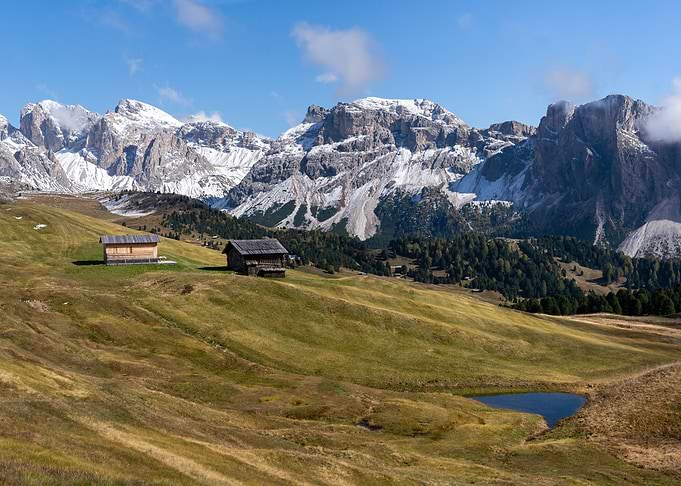 Green mountain landscape with lonely cabin
