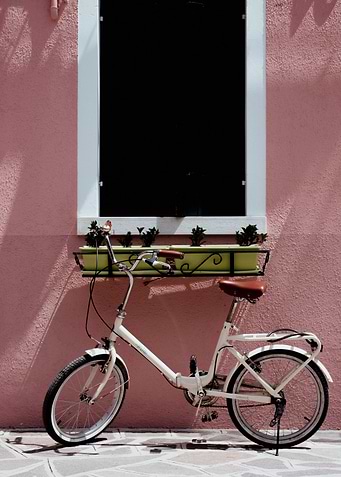 White Bicycle Against Pink Wall