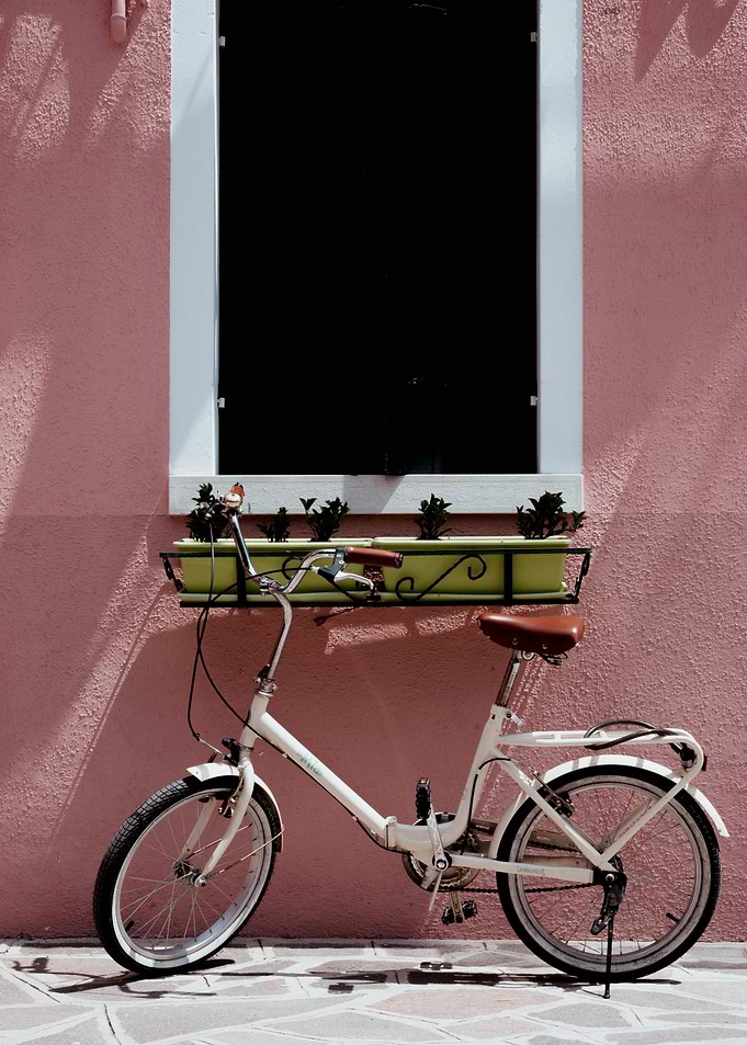 White Bicycle Against Pink Wall