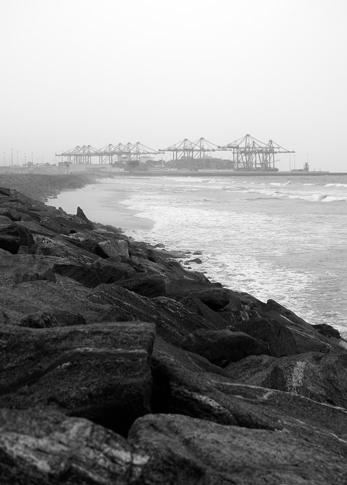 Harbor Cranes and Rocky Shore