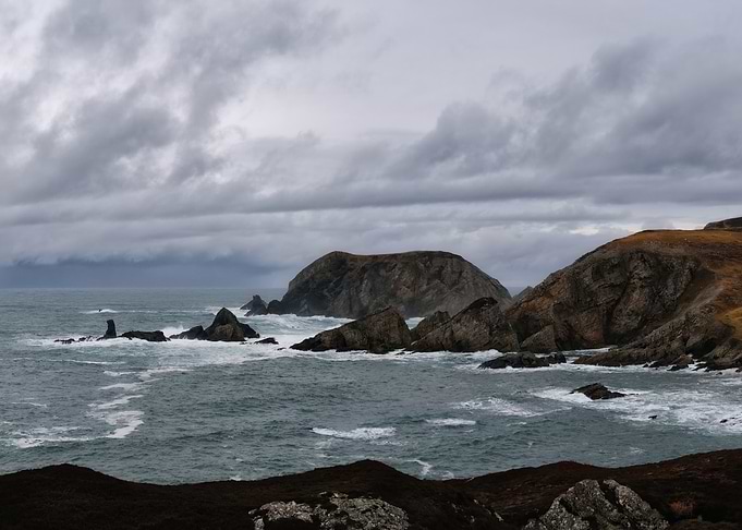 Dramatic Rocky Coastline Under Cloudy Sky
