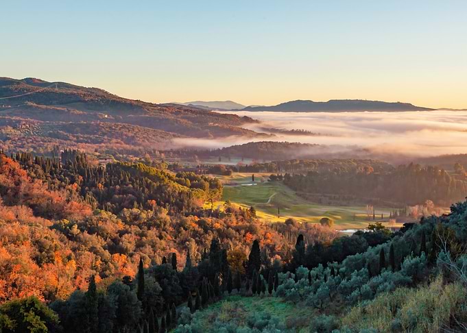 Tuscany countryside rolling hills at sunrise with fog covering the valley