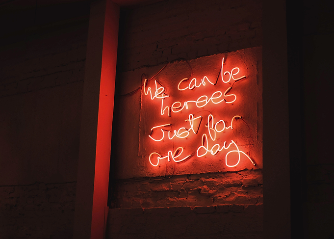 London, England I Vibrant red neon mantra captured in a restaurant window with a warm urban ambience with an inspiring phrase about we can be heroes just for one day with a luminous decor light
