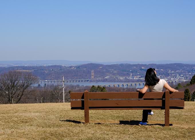 Woman on Bench with River View