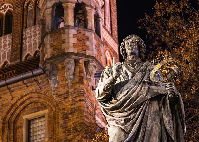 Marvel at the Nicolaus Copernicus Monument under the night sky