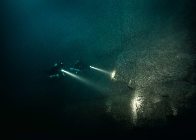 Scuba Divers Exploring Underwater Cave