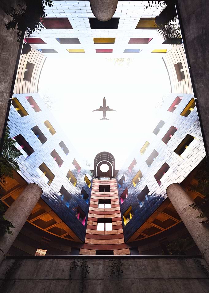 Airplane Over Modern Building