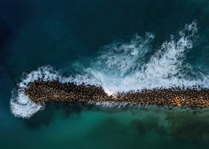 Aerial view of waves crashing on rocks