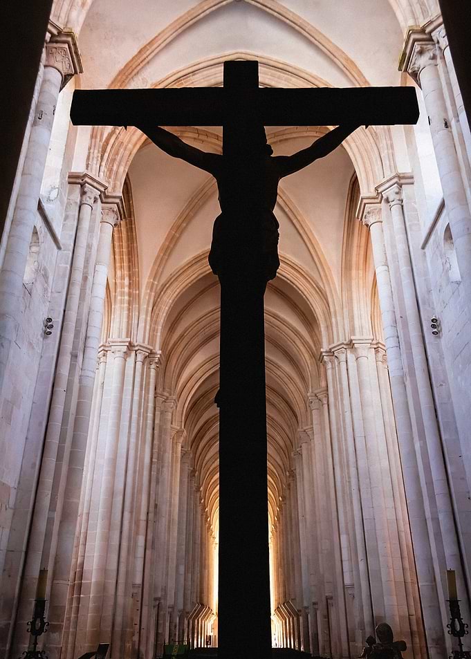 Crucifix Silhouette with Jesus Christ Nailed to Cross. Gothic Monastery of Alcobaca Abbey, Portugal