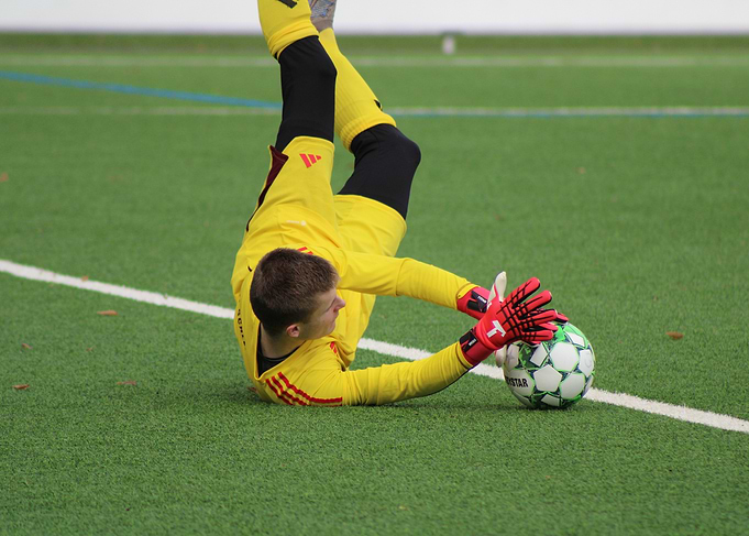 Goalkeeper diving for soccer ball