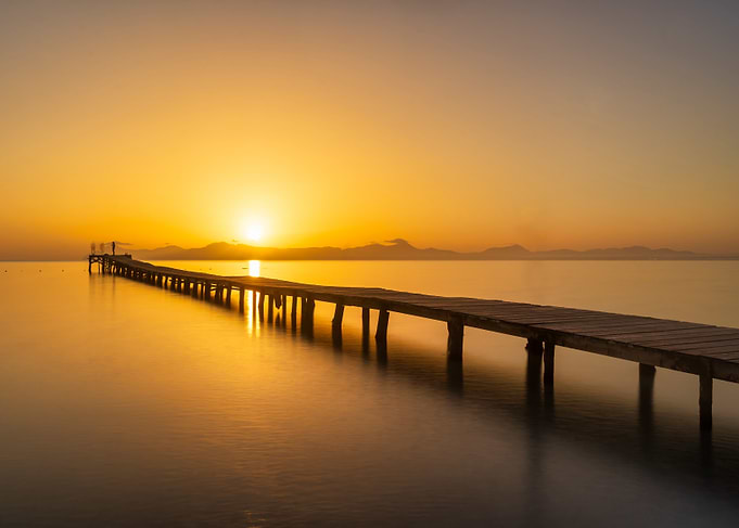 Golden Sunset Over Wooden Pier at Calm Sea