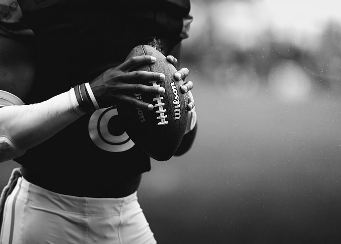 Football Player Holding Wilson Football