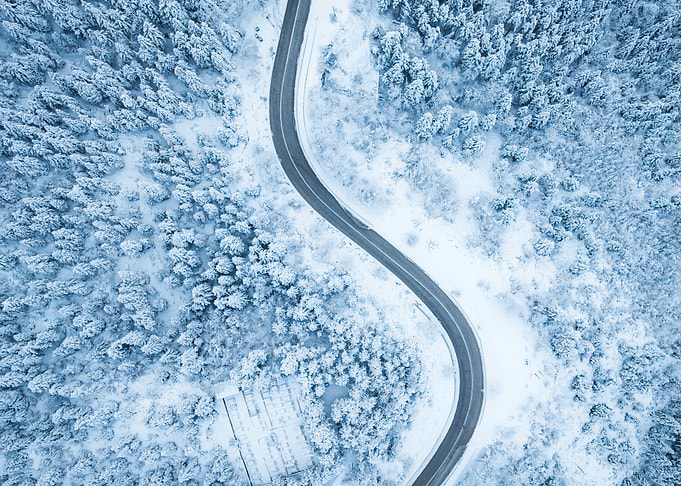 Winter road through snowy forest