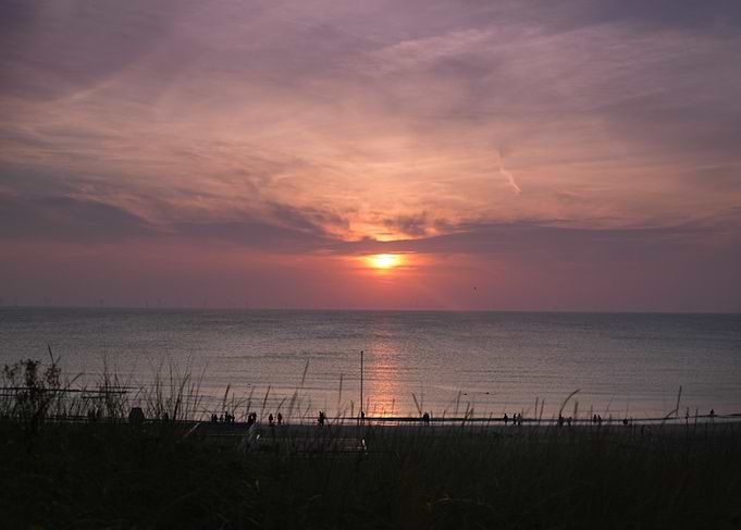 Sunset over the ocean with people