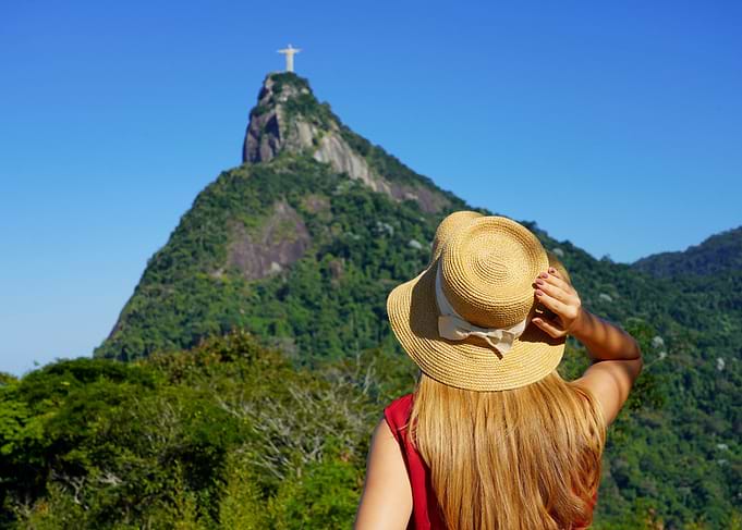 Woman with hat looking at Christ the Redeemer, Rio de Janeiro, Brazil