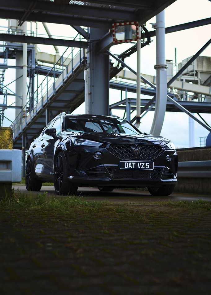 Sleek Black Car Under Industrial Structure