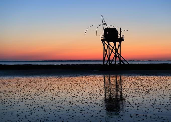 Silhouette of fishing hut at sunset