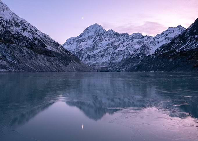 Snowy Mountains Reflecting in Frozen Lake