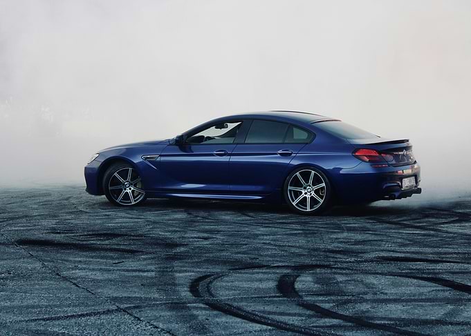 Blue BMW drifting in smoke