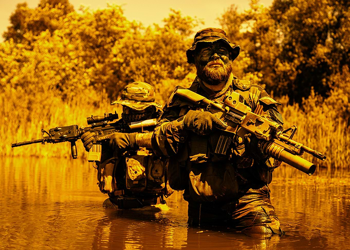 Two soldiers in water with rifles