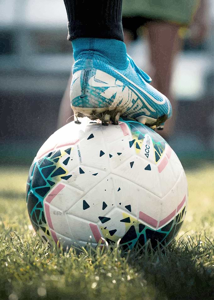 Soccer ball and cleat on grass