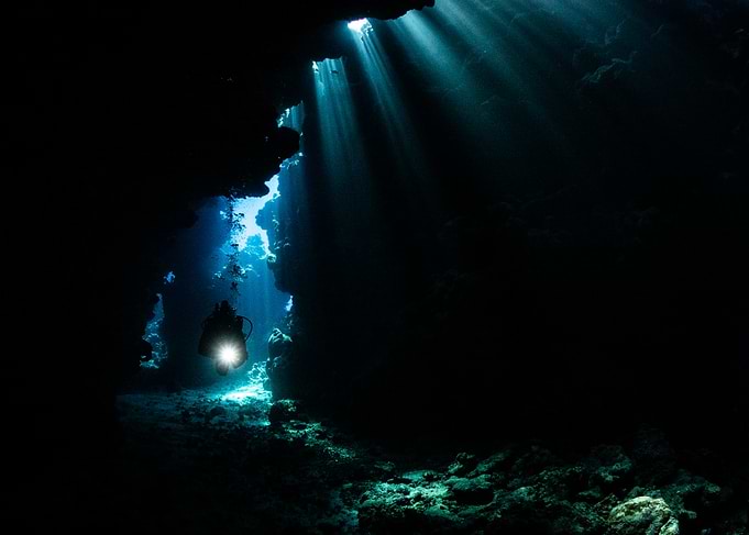 Diver in Underwater Cave with Light