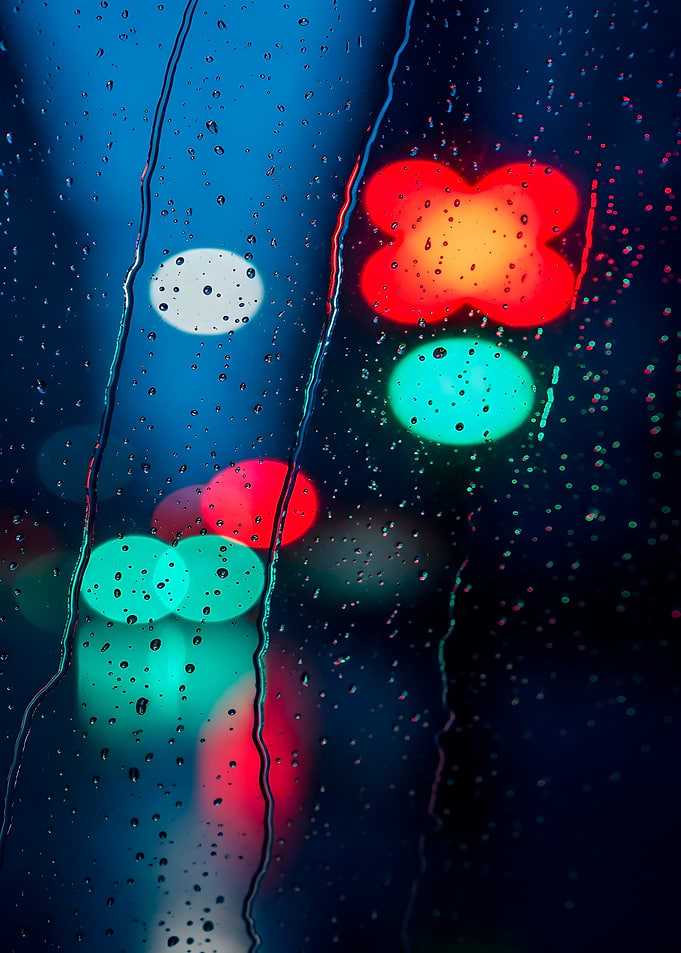 Raindrops on glass with blurred lights