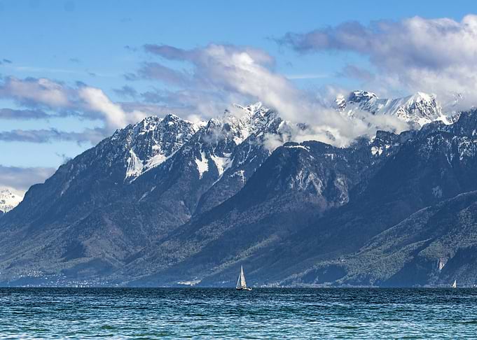 Lake Leman with the Alps mountain range and Sailboat