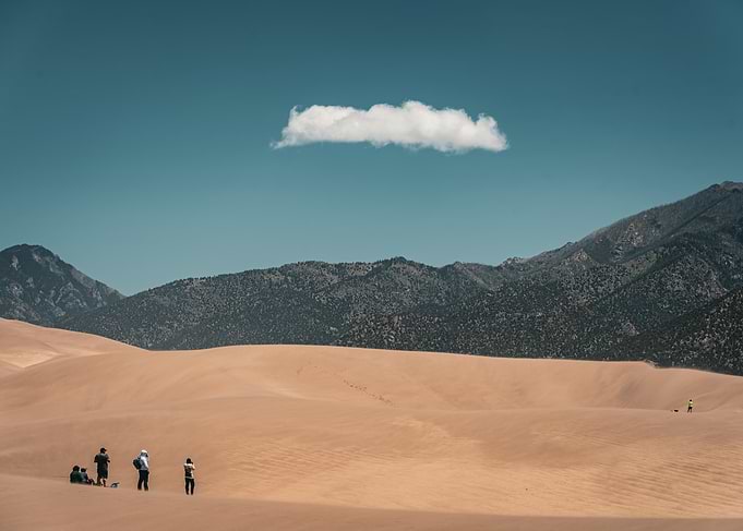 Sand Dunes with People and Mountains